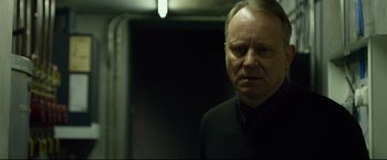 Movie still from “The Girl with the Dragon Tattoo” (2011), directed by David Fincher – An older man wearing a black shirt and a black tie; Close Up shot, Over the shoulder angle