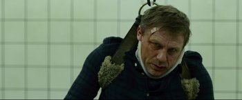 Movie still from “The Girl with the Dragon Tattoo” (2011), directed by David Fincher – A man holding a knife over his shoulder; Close Up shot, Low angle