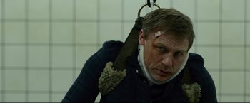 Movie still from “The Girl with the Dragon Tattoo” (2011), directed by David Fincher – A man wearing a neck brace with a broken arm; Close Up shot, Low angle