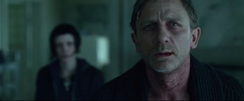 Movie still from “The Girl with the Dragon Tattoo” (2011), directed by David Fincher – A person in a room near a wall; Close Up shot, Over the shoulder angle