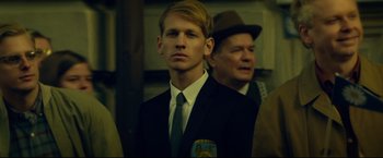 Movie still from “The Girl with the Dragon Tattoo” (2011), directed by David Fincher – A man in a suit and tie standing next to another man in a suit and tie; Close Up shot, Over the shoulder angle