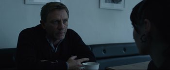 Movie still from “The Girl with the Dragon Tattoo” (2011), directed by David Fincher – A man sitting at a table with a cup of coffee; Close Up shot, Over the shoulder angle