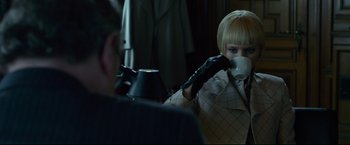 Movie still from “The Girl with the Dragon Tattoo” (2011), directed by David Fincher – A woman drinking a cup of coffee in front of a man; Medium shot, Over the shoulder angle