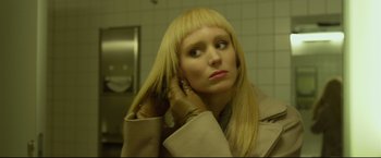 Movie still from “The Girl with the Dragon Tattoo” (2011), directed by David Fincher – A woman with blonde straight hair looking into a mirror; Close Up shot, Low angle