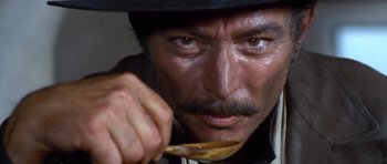 Movie still from “The Good, the Bad and the Ugly” (1966), directed by Sergio Leone – A person holding a spoon of food; Extreme Close Up shot, Low angle