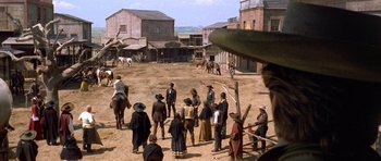 Movie still from “The Good, the Bad and the Ugly” (1966), directed by Sergio Leone – A group of people standing on top of a dirt field; Extreme Wide shot, Over the shoulder angle