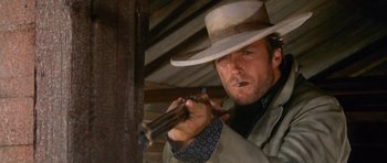 Movie still from “The Good, the Bad and the Ugly” (1966), directed by Sergio Leone – A man holding a gun while wearing a cowboy hat; Close Up shot, Low angle