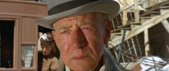 Movie still from “The Good, the Bad and the Ugly” (1966), directed by Sergio Leone – An old man wearing a white hat and a brown jacket; Close Up shot, Low angle