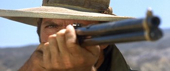 Movie still from “The Good, the Bad and the Ugly” (1966), directed by Sergio Leone – A person holding a gun; Extreme Close Up shot, Low angle