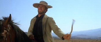 Movie still from “The Good, the Bad and the Ugly” (1966), directed by Sergio Leone – A man in a cowboy hat holding a whip; Medium shot, Low angle
