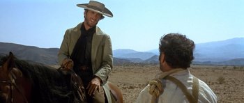 Movie still from “The Good, the Bad and the Ugly” (1966), directed by Sergio Leone – A man wearing a cowboy hat sitting on a horse; Medium shot, Over the shoulder angle
