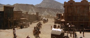 Movie still from “The Good, the Bad and the Ugly” (1966), directed by Sergio Leone – A group of people riding horses down a dirt road; Extreme Wide shot, High angle