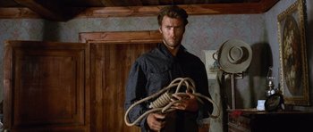 Movie still from “The Good, the Bad and the Ugly” (1966), directed by Sergio Leone – A man holding a bunch of ropes in his hands; Medium shot, Low angle
