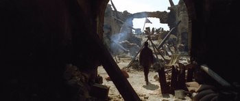 Movie still from “The Good, the Bad and the Ugly” (1966), directed by Sergio Leone – A man walking through the ruins of a building; Wide shot, Low angle