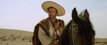 Movie still from “The Good, the Bad and the Ugly” (1966), directed by Sergio Leone – A man wearing a sombrero on top of a horse; Close Up shot, Low angle