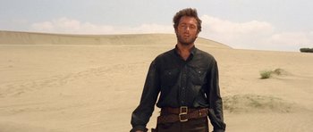 Movie still from “The Good, the Bad and the Ugly” (1966), directed by Sergio Leone – A man standing in the middle of the desert; Medium shot, Low angle