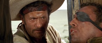 Movie still from “The Good, the Bad and the Ugly” (1966), directed by Sergio Leone – A person holding a sword; Close Up shot, Over the shoulder angle