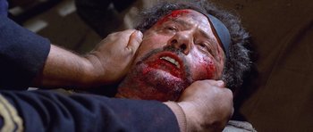 Movie still from “The Good, the Bad and the Ugly” (1966), directed by Sergio Leone – A man with blood all over his face and head; Close Up shot, Overhead angle