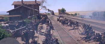 Movie still from “The Good, the Bad and the Ugly” (1966), directed by Sergio Leone – A group of people standing on the side of a train track; Extreme Wide shot, High angle