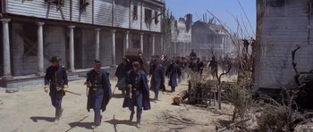 Movie still from “The Good, the Bad and the Ugly” (1966), directed by Sergio Leone – A group of men walking down a dirt road; Wide shot, High angle