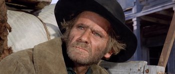 Movie still from “The Good, the Bad and the Ugly” (1966), directed by Sergio Leone – An old man with a beard wearing a black hat; Close Up shot, Low angle