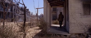 Movie still from “The Good, the Bad and the Ugly” (1966), directed by Sergio Leone – A man walking on the porch of an abandoned house; Wide shot, Low angle