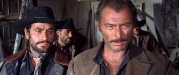 Movie still from “The Good, the Bad and the Ugly” (1966), directed by Sergio Leone – A group of men standing next to each other in a room; Close Up shot, Over the shoulder angle