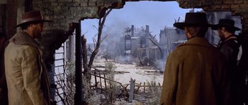 Movie still from “The Good, the Bad and the Ugly” (1966), directed by Sergio Leone – An open window looking out on a destroyed town; Wide shot, Over the shoulder angle