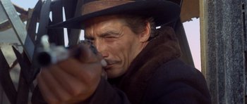 Movie still from “The Good, the Bad and the Ugly” (1966), directed by Sergio Leone – A person holding a gun; Close Up shot, Low angle