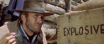 Movie still from “The Good, the Bad and the Ugly” (1966), directed by Sergio Leone – A man wearing a hat standing next to a wooden box; Close Up shot, Low angle