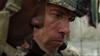 Movie still from “The Hurt Locker” (2008), directed by Kathryn Bigelow – A person wearing a helmet; Close Up shot, Over the shoulder angle