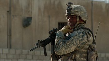 Movie still from “The Hurt Locker” (2008), directed by Kathryn Bigelow – A man in camouflage holding a rifle in his hands; Medium shot, Low angle