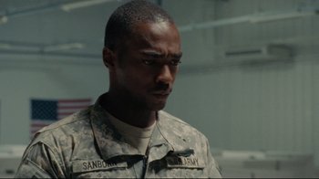 Movie still from “The Hurt Locker” (2008), directed by Kathryn Bigelow – A man in military fatigues is looking down; Close Up shot, Over the shoulder angle