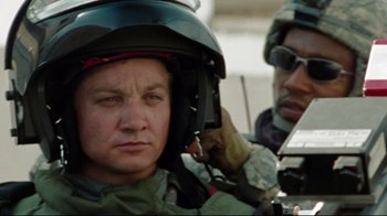 Movie still from “The Hurt Locker” (2008), directed by Kathryn Bigelow – A man wearing a helmet while another man adjusts his helmet; Close Up shot, Over the shoulder angle