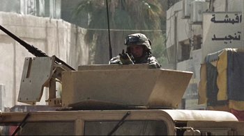 Movie still from “The Hurt Locker” (2008), directed by Kathryn Bigelow – A soldier sitting on top of an armored vehicle; Medium shot, Low angle