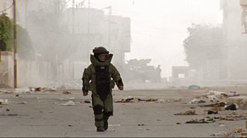 Movie still from “The Hurt Locker” (2008), directed by Kathryn Bigelow – A man in a hazmat suit walking down a street; Wide shot, Low angle