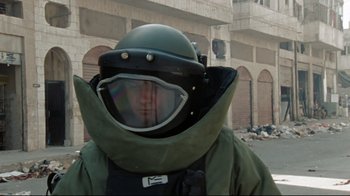 Movie still from “The Hurt Locker” (2008), directed by Kathryn Bigelow – A man wearing a helmet and a green jacket; Medium shot, Low angle