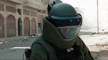 Movie still from “The Hurt Locker” (2008), directed by Kathryn Bigelow – A man wearing a helmet and a green jacket; Close Up shot, Low angle