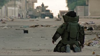 Movie still from “The Hurt Locker” (2008), directed by Kathryn Bigelow – A soldier sitting on the ground in the middle of a street; Wide shot, High angle