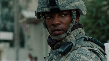 Movie still from “The Hurt Locker” (2008), directed by Kathryn Bigelow – A man in a military uniform with a cell phone in his hand; Close Up shot, Over the shoulder angle