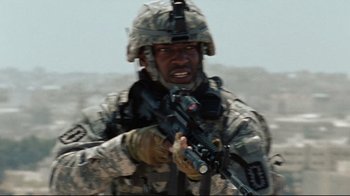 Movie still from “The Hurt Locker” (2008), directed by Kathryn Bigelow – A man in a military uniform holding a rifle; Medium shot, Low angle