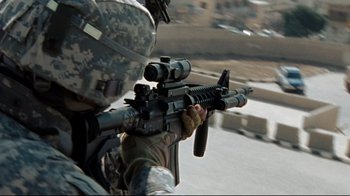 Movie still from “The Hurt Locker” (2008), directed by Kathryn Bigelow – A soldier is holding a rifle and aiming it; Medium shot, Low angle