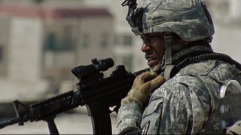Movie still from “The Hurt Locker” (2008), directed by Kathryn Bigelow – A man in a military uniform is holding a rifle; Medium shot, Low angle