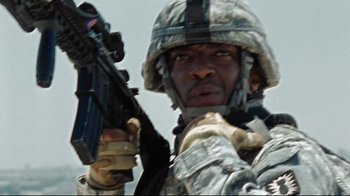 Movie still from “The Hurt Locker” (2008), directed by Kathryn Bigelow – A man in a military uniform holding a gun; Close Up shot, Low angle