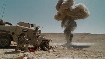 Movie still from “The Hurt Locker” (2008), directed by Kathryn Bigelow – A group of soldiers sitting next to each other in the desert; Extreme Wide shot, High angle