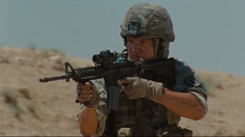 Movie still from “The Hurt Locker” (2008), directed by Kathryn Bigelow – A man in a military uniform is holding a gun; Medium shot, Low angle