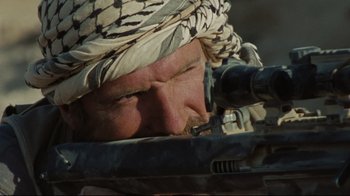 Movie still from “The Hurt Locker” (2008), directed by Kathryn Bigelow – A person with a rifle; Close Up shot, Over the shoulder angle