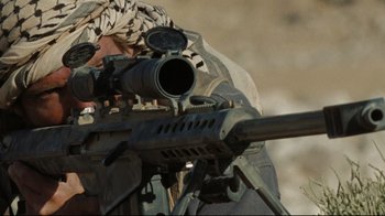 Movie still from “The Hurt Locker” (2008), directed by Kathryn Bigelow – A man with a rifle aiming at something in the distance; Extreme Close Up shot, Over the shoulder angle