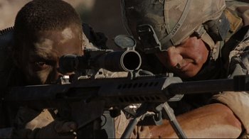 Movie still from “The Hurt Locker” (2008), directed by Kathryn Bigelow – A man is holding a rifle and aiming it at a target; Medium shot, Over the shoulder angle