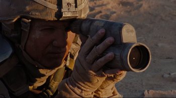Movie still from “The Hurt Locker” (2008), directed by Kathryn Bigelow – A soldier is taking a picture with a camera; Close Up shot, High angle
